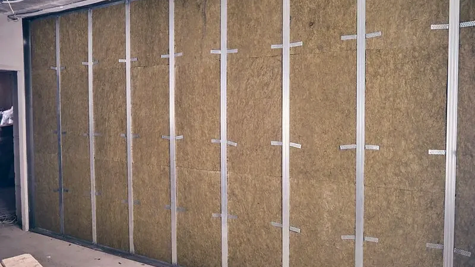 Mineral wool acoustic insulation installed in a framed wall cavity