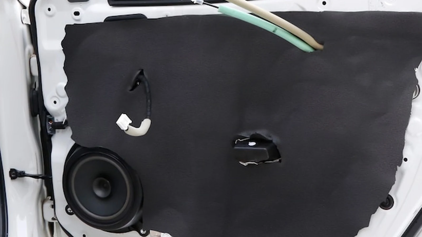 Sound deadening for car doors with acoustic treatment around the inner door speaker